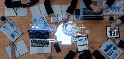 A modern business meeting showcasing collaboration and the integration of artificial intelligence. Digital analytics displayed on laptops and tablets enhance decision-making and productivity. Trope