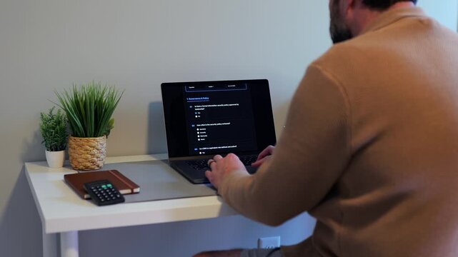 Middle Aged Man Working Remotely From Home Conducting Cybersecurity Audit for Consulting Firm - Information Security Concept