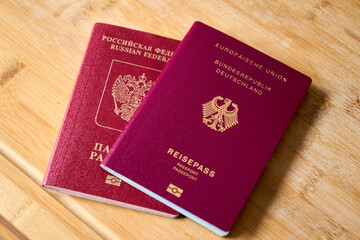 Photograph of Russian and German international passports placed side by side. The image represents...