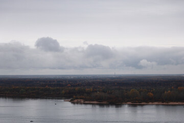 A Panoramic View Of A Calm River, An Autumn Forest On The Horizon, And A Heavy, Overcast Sky, A Sad And Moody Scene.