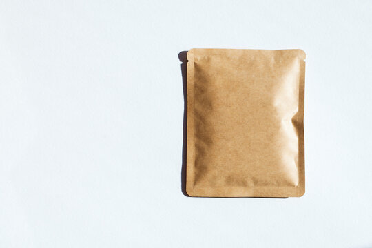 Blank craft plastic pouch, white pack on studio background with shadow, mylar bag isolated for coffee or food, cosmetic products, snack, candy. Different sizes, mock up.