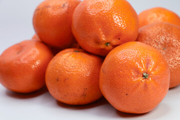 A Macro Shot Of A Pile Of Bright, Juicy And Ripe Tangerines Or Clementines With Textured Skin.
