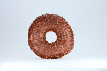 A Single Round Donut With Chocolate Glaze And Sprinkles, Isolated On A Clean White Background, A Concept Of Sweet Dessert.