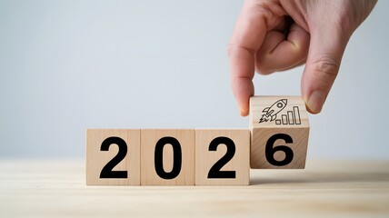 2026 business growth concept with wooden blocks and hand placing upward graph symbol