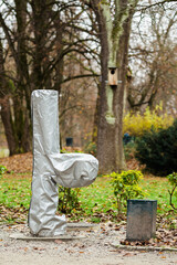 Fountain in a park covered with a protective plastic wrap to shield it from frost and cold winter temperatures