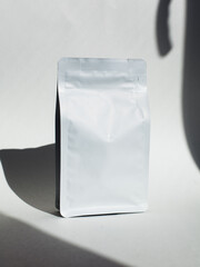 Blank craft plastic pouch, white pack on studio background with shadow, mylar bag isolated for coffee or food, cosmetic products, snack, candy. Different sizes, mock up.
