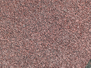 Fondo de textura granular y rugosa de pequeños gránulos en tono rojo oscuro o marrón asfalto