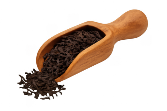 Dried black loose leaf tea spilling from scoop