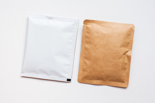 Blank craft plastic pouch, white pack on studio background with shadow, mylar bag isolated for coffee or food, cosmetic products, snack, candy. Different sizes, mock up.