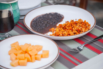 Desayuno huevos con chorizo acompa&ntilde;ado por Frijoles y un plato de Melon