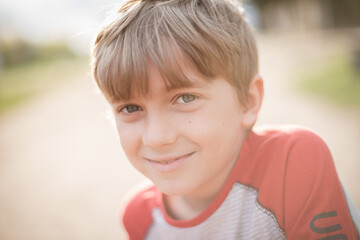 Portrai of the young smiling boy during sunny summer day