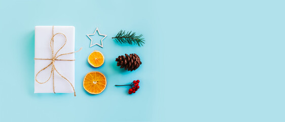 Collection of Christmas objects - gift box, frame, eve fir, dried orange, pine cone, star. New Year and winter minimal holiday frame composition. Flat lay, top view, place for text.