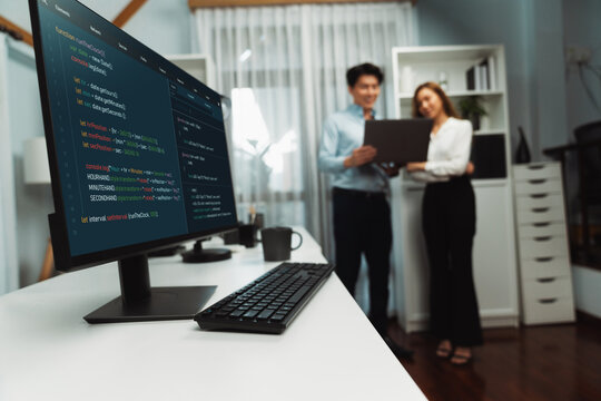 Running on coding programming intelligence system on computer screen with blurry IT developers standing with laptop at corner modern office, talking online software development information. Infobahn. - Powered by Adobe