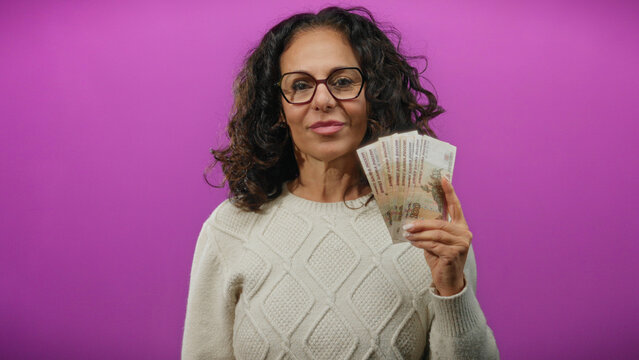 Woman holding russian ruble banknotes against a vibrant purple background, showcasing finance and currency themes with a confident expression. - Powered by Adobe