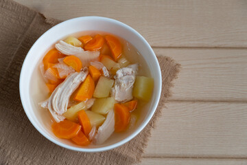 Homemade chicken soup with vegetables in a white bowl