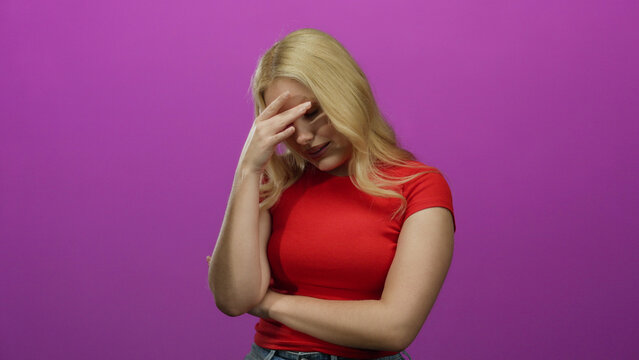 Young blonde woman wearing red top poses against pink background, exhibiting expressions of contemplation and worry, illustrating human emotions and modern fashion style.