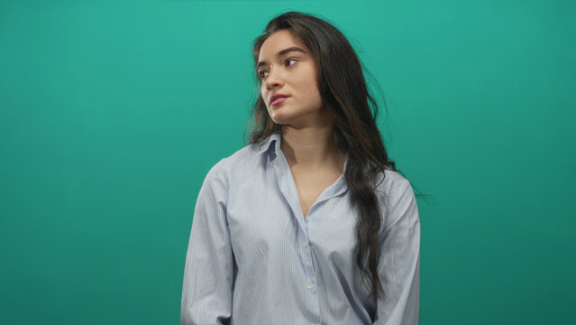 Woman wearing striped shirt and stud earring rotates head in studio; serenity contemplation focus presence. - Powered by Adobe