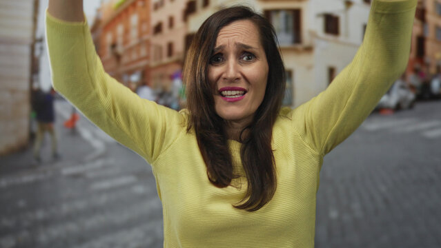 Woman gesturing passionately on bustling street showing her vibrant personality and expressive emotion while surrounded by urban scenery and lively atmosphere.