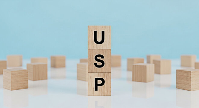 Wooden blocks spelling usp on a white surface against a blue background representing unique selling proposition and business strategy concept