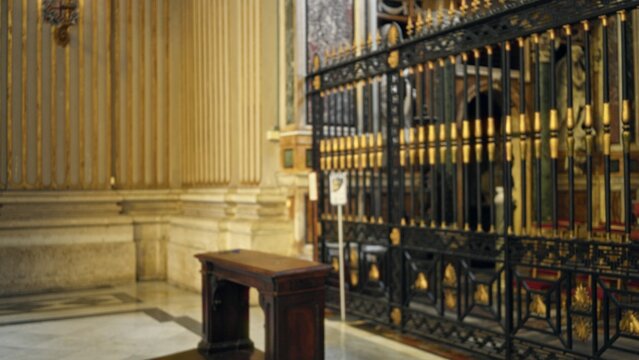 Ornate church interior with decorative iron grille and marble floor, defocused soft bokeh background church; background backplate copyspace template calm.