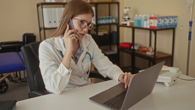 Woman in white coat with stethoscope holds phone to ear and types on laptop in clinic; concentration. - Powered by Adobe