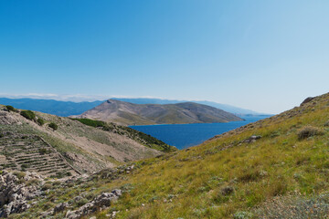 Scenic coastal view of krk island with clear blue sky and rugged landscape