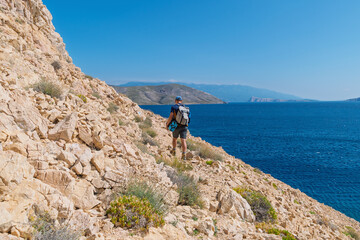 Young caucasian male hiking on rocky coastal trail with ocean view. Hiking trail near Baška, Krk Island, Croatia