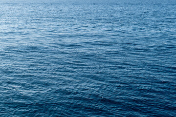 Tranquil blue ocean surface with gentle waves under clear sky