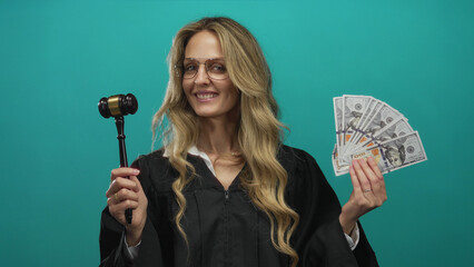 Woman judge in uniform holding us dollars and gavel against green background, symbolizing justice and money in the usa.