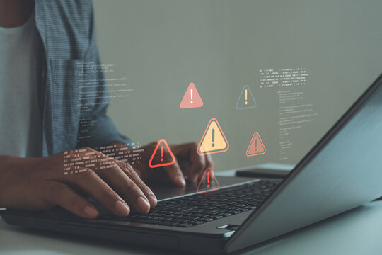 Cybersecurity concept showing a programmer typing on laptop with warning alert icons and code errors, symbolizing data breach, system vulnerability and cyber threat detection in digital networks.