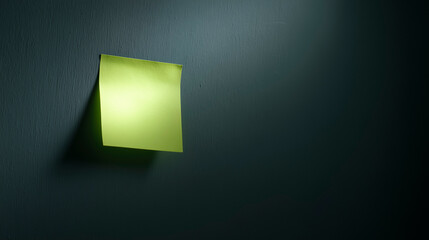 A sticky note on a dark, empty office wall