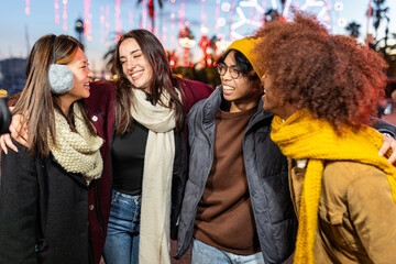 Multiracial group of young people having fun on winter standing outdoors. Friendship and youth community concept