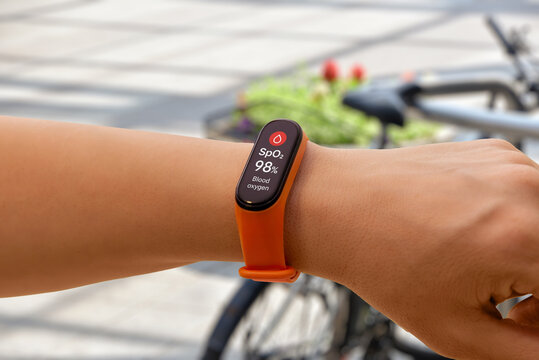 Smart band measuring blood oxygen level outdoors, showing SpO2 data for wellness, breathing efficiency, and overall health insights