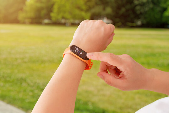 Smart band displaying activity progress outdoors, capturing movement, daily tracking, and active lifestyle motivation in a natural park environment