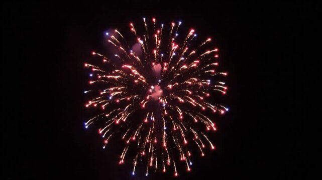 Glowing light, possibly a firework, against a backdrop of deep darkness, with a small trail