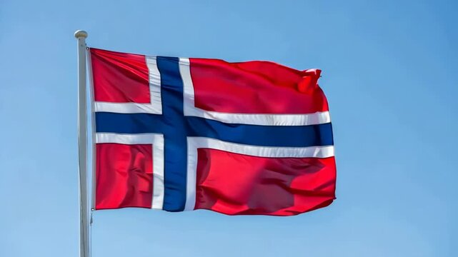 Norwegian flag waving proudly in the blue sky. National symbol of Norway flying high, representing freedom and national identity.