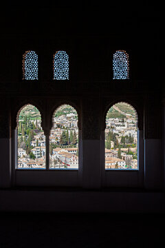 View of Granada through arched windows in the Nasrid Palaces