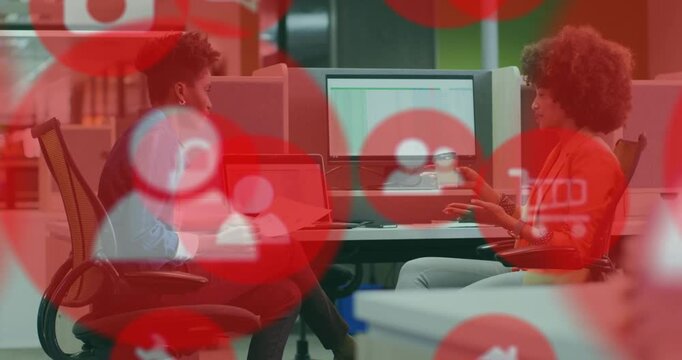 Red overlay fading as two staff checking business spreadsheet, left using laptop, right gesturing