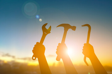 Silhouette Hands Holding Tools Against Sunrise