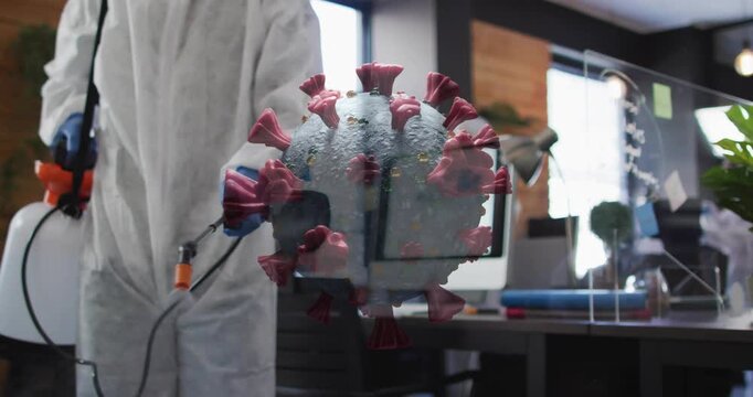 Cleaner entering office spraying plexi shields and desks for health on rotating virus over desks