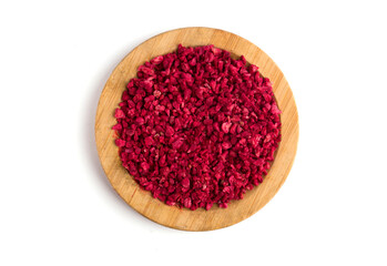A wooden plate with a dry piece of raspberry on a white background