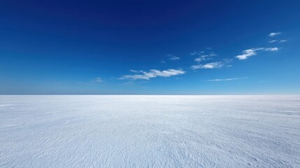 Vast White Snowy Landscape Under Clear Blue Sky with Few Wispy Clouds and Serene Atmosphere Ideal for Winter and Nature Photography