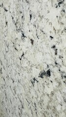 Close-up texture of white and black granite countertop surface with purple hue