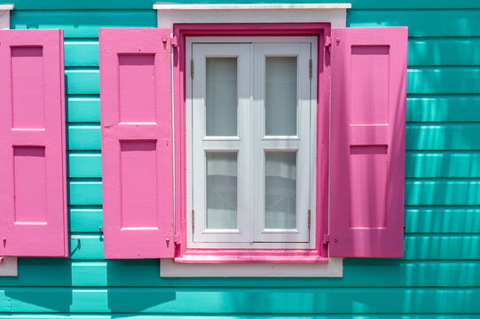 Abstract bright colourful Caribbean architectural details of window shutters on a tongue and groove siding board house