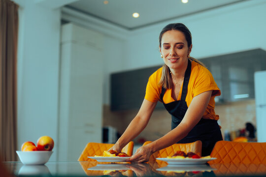 Happy Mother Setting the Table for her Whole Family. Cheerful housewife arranges the plates for her family dinner