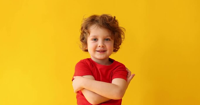 Cute little boy posing on orange background