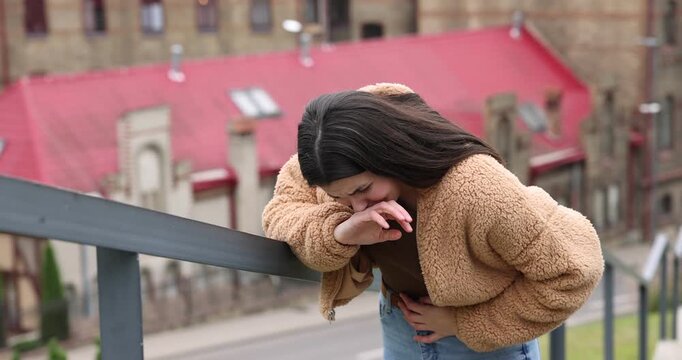 Young woman suffering from stomachache and nausea outdoors