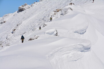 谷川岳の巨大な雪庇と登山者
