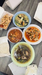 Delicious homemade food spread featuring various dishes and a takeaway box