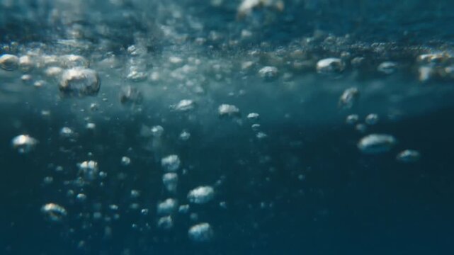 Underwater Bubbles Rising Through Clear Ocean Water In Deep Blue Sea With Sunlight And Calm Motion